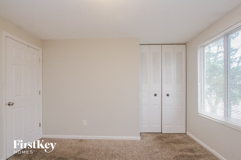 a bedroom with two closets and a carpeted floor