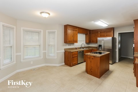 A kitchen with wooden cabinets and a tiled floor.