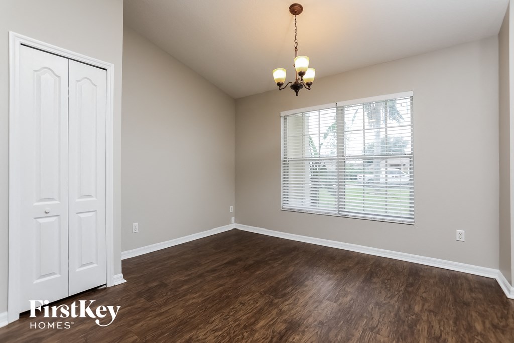an empty living room with wood floors and a large window