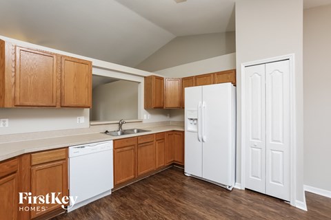 a kitchen with white appliances and wooden cabinets