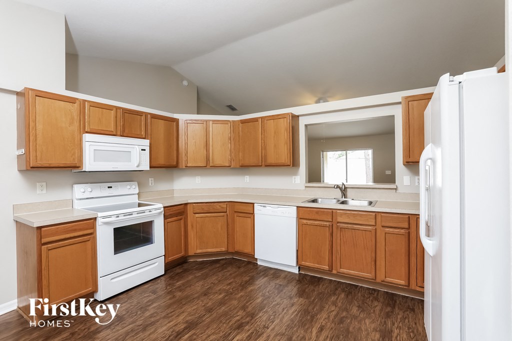a kitchen with white appliances and wooden cabinets