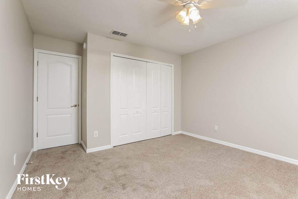a bedroom with two closets and a ceiling fan
