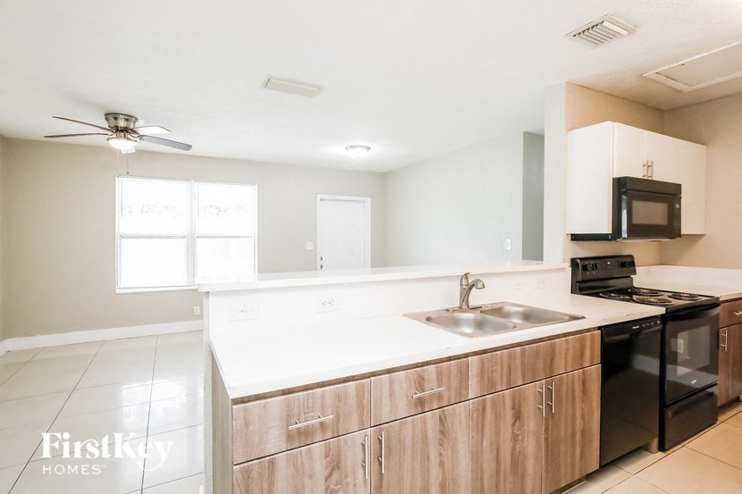 a kitchen with wooden cabinets and white counter tops and a sink