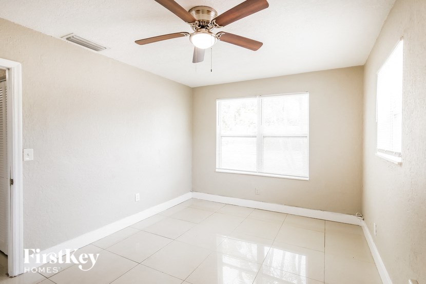 a empty living room with a ceiling fan and a window
