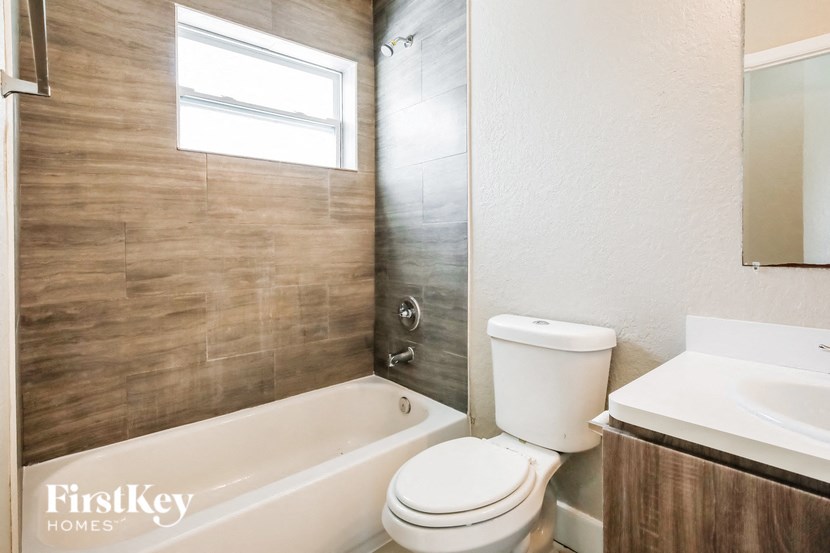 a bathroom with a toilet and a tub and a sink