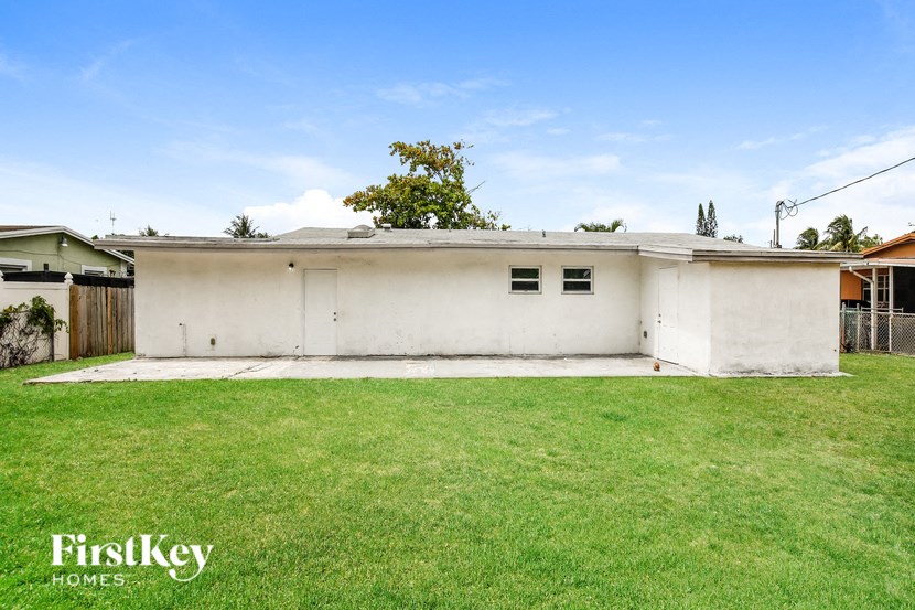 a small white house with a grassy yard in front