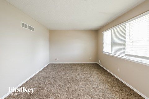 an empty room with carpet and a large window
