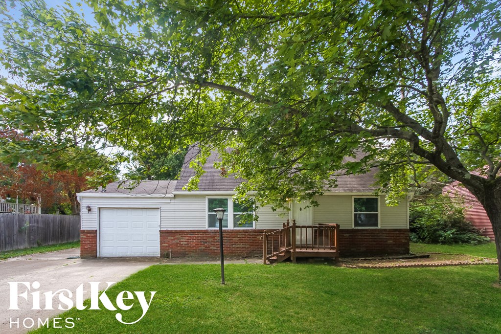 a small house with a yard and a tree