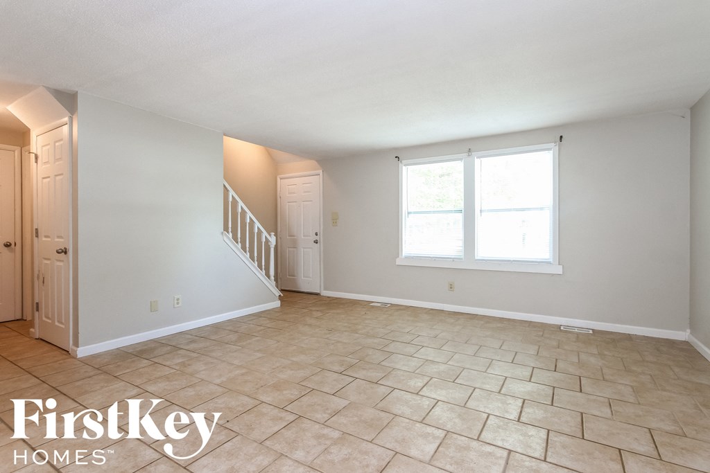 the living room has a staircase and a large window