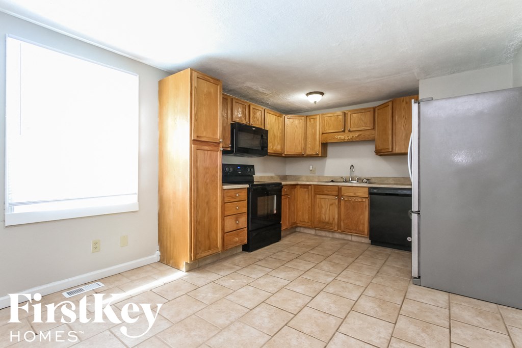 a kitchen with wooden cabinets and a stainless steel refrigerator