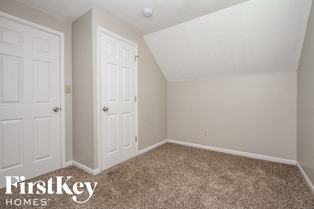 a bedroom with two closets and a carpeted floor