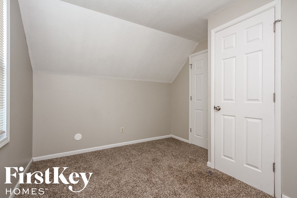 a bedroom with a white door and a carpeted floor