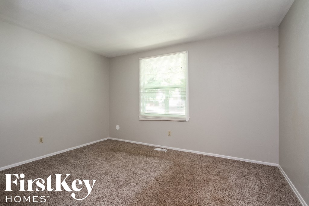 a bedroom with a carpeted floor and a window