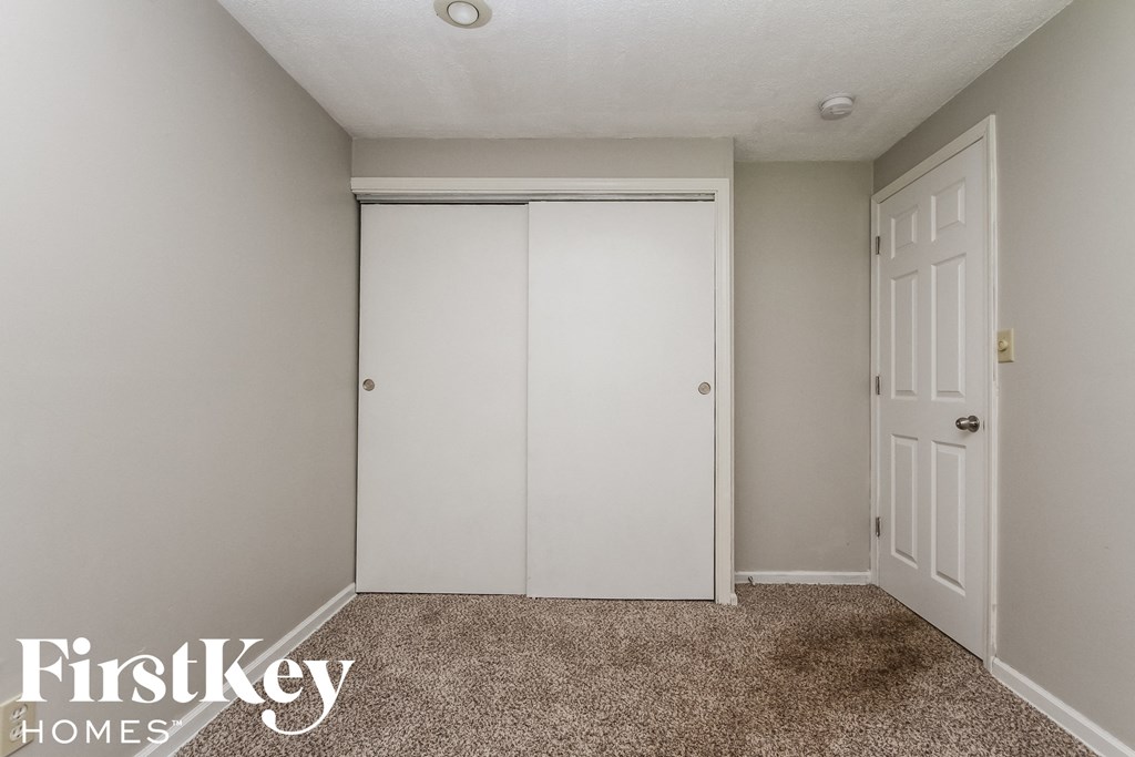a bedroom with a closet and a white door