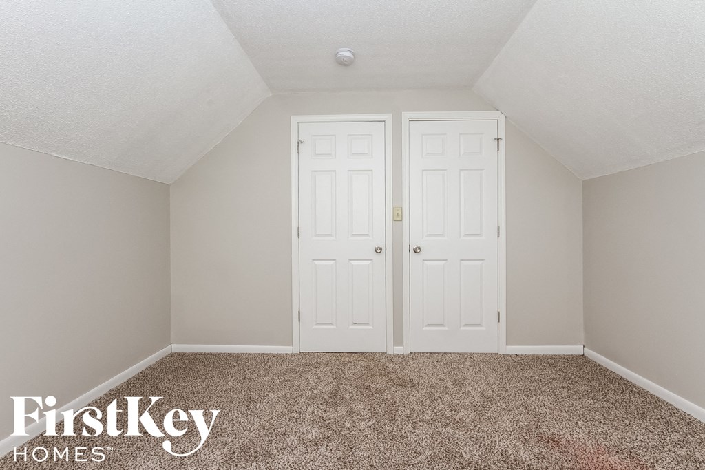 a bedroom with two doors and a carpeted floor