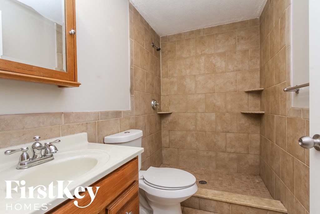 a bathroom with a toilet and a sink and a mirror