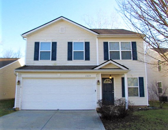 A two-story house with a white garage door.