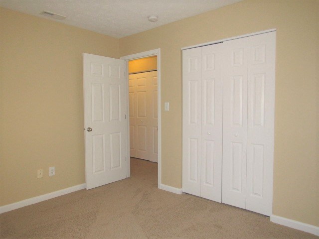 A room with two white doors, one of which is open.