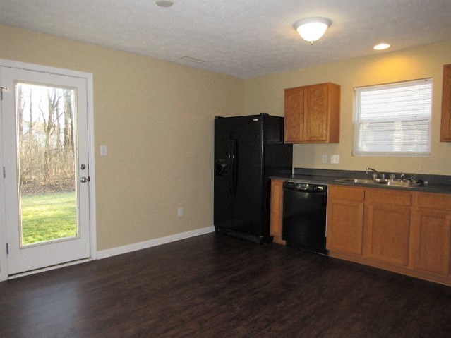 A kitchen with black appliances and wooden cabinets.