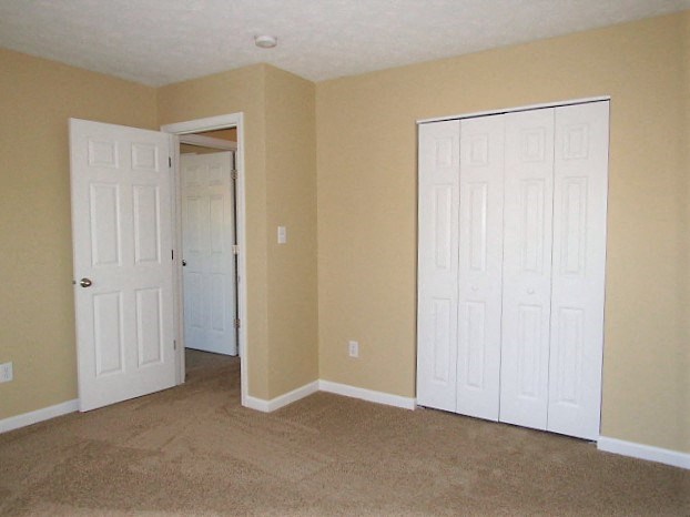 A room with two white doors and beige walls.