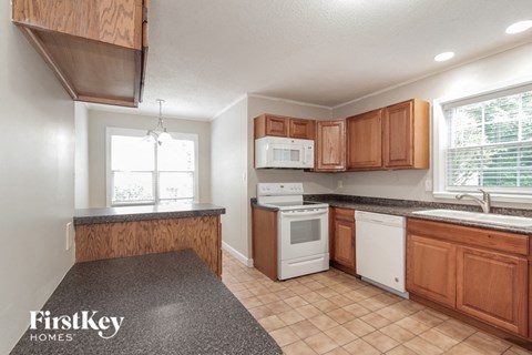 A kitchen with wooden cabinets and a granite countertop.