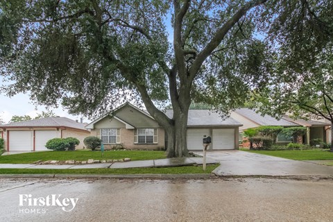 A tree in front of a house with the words "FirstKey Homes" on the bottom left.