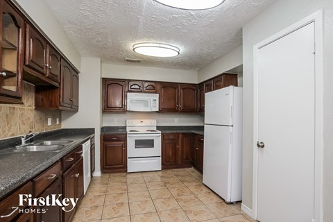 A kitchen with brown cabinets and a white refrigerator.