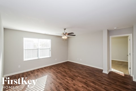 a living room with wood flooring and a ceiling fan