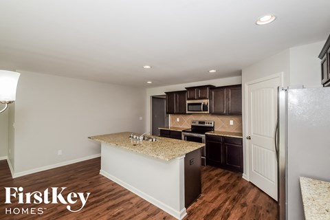 a kitchen with a granite counter top and a stainless steel refrigerator