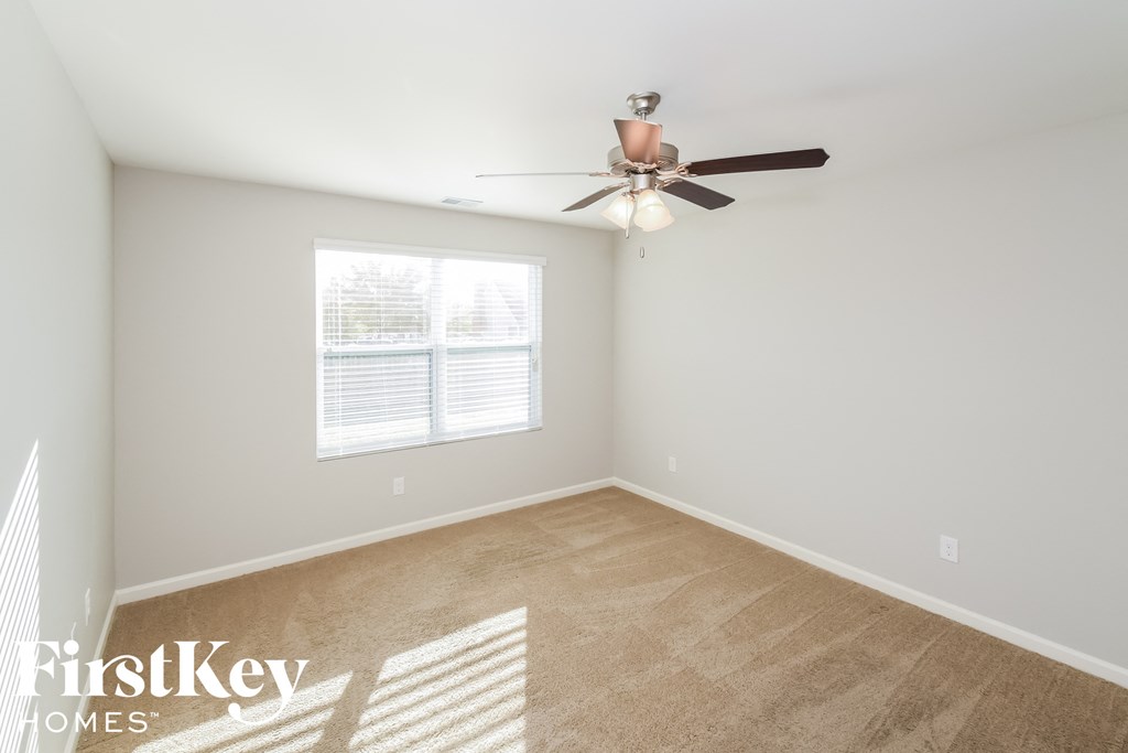 a bedroom with a ceiling fan and a window