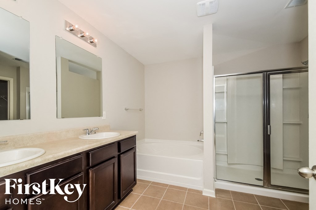 a bathroom with two sinks and a shower and a mirror