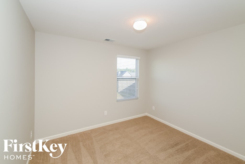 a bedroom with white walls and a window