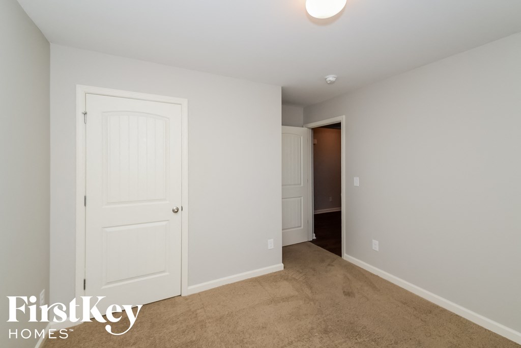 a bedroom with a closet and a door to a hallway