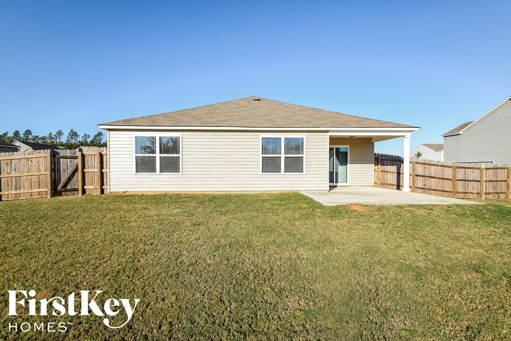 a small white house with a yard and a fence