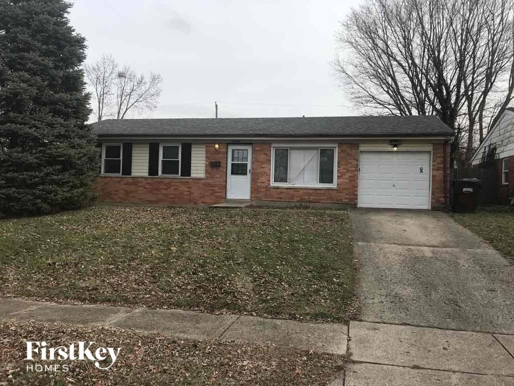 A brick house with a white door and a garage door.