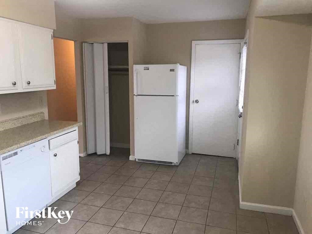 A kitchen with white appliances and cabinets.