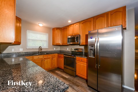 A kitchen with wooden cabinets and a granite countertop.