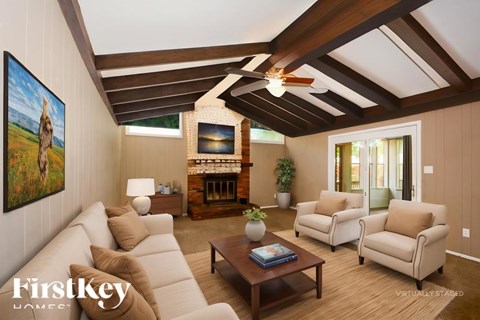 A living room with a large painting of a giraffe on the wall.