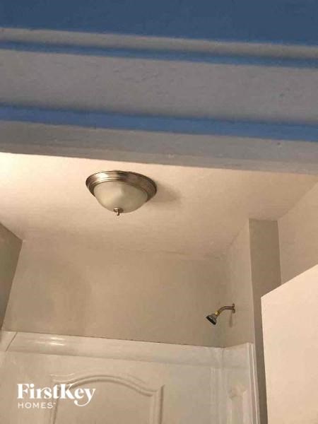 a bathroom with a ceiling light and a shower