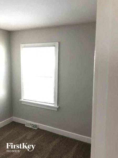 a small room with a window and a brown floor