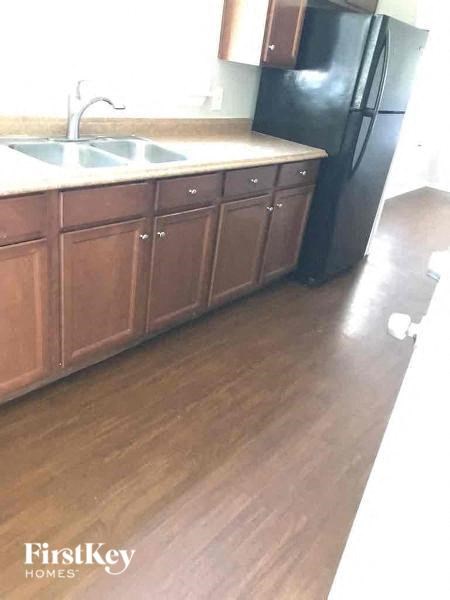 a kitchen with wooden floors and a sink and a refrigerator