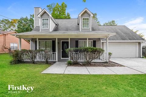 the front of a house with a porch and a driveway