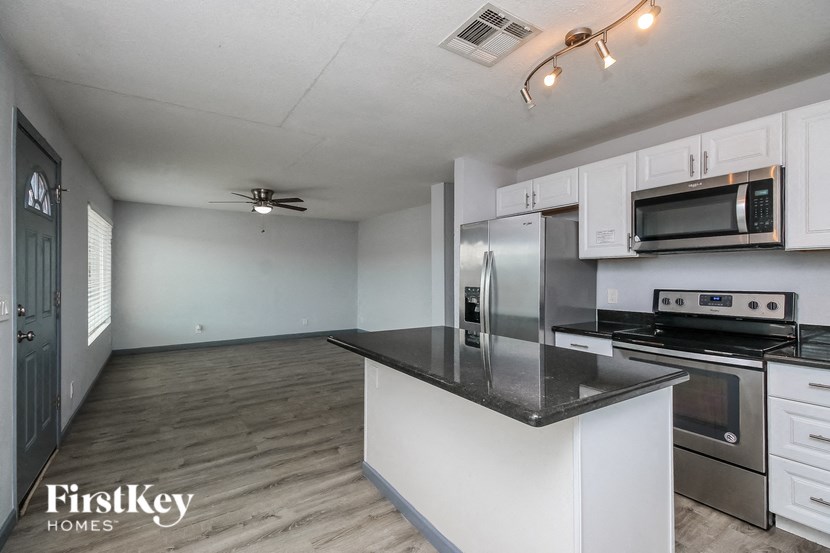 A kitchen with a stainless steel refrigerator, microwave, and oven.