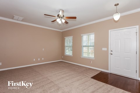 a living room with a ceiling fan and a white door