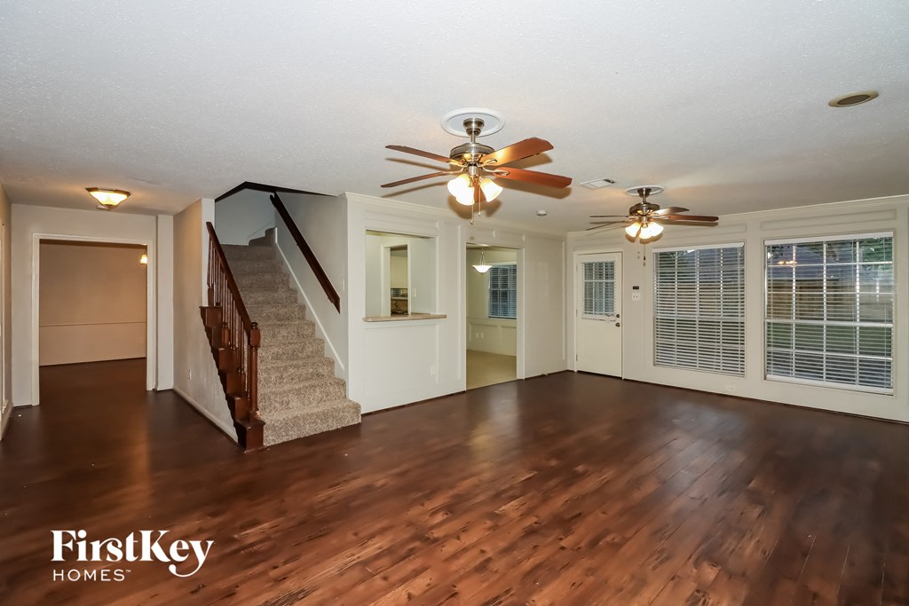 the living room with hardwood floors and a ceiling fan