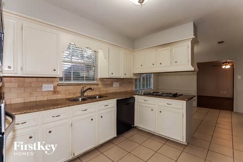 a kitchen with white cabinets and counters and a sink