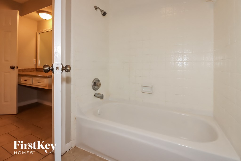 a white bath tub in a bathroom with a sink and a mirror