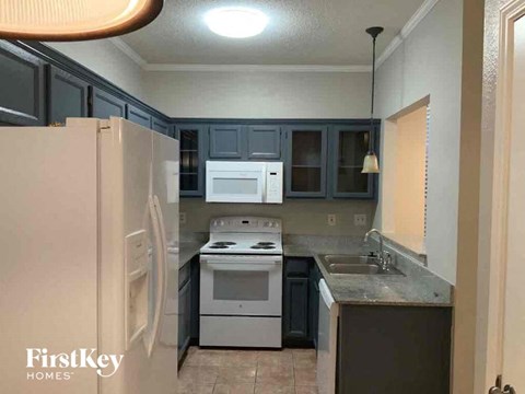 A kitchen with a white fridge and a white stove top oven.