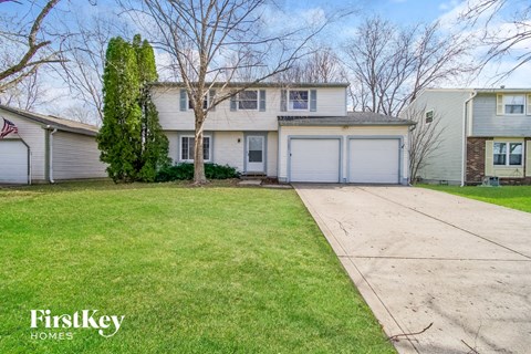 A house with a large front yard and a garage.