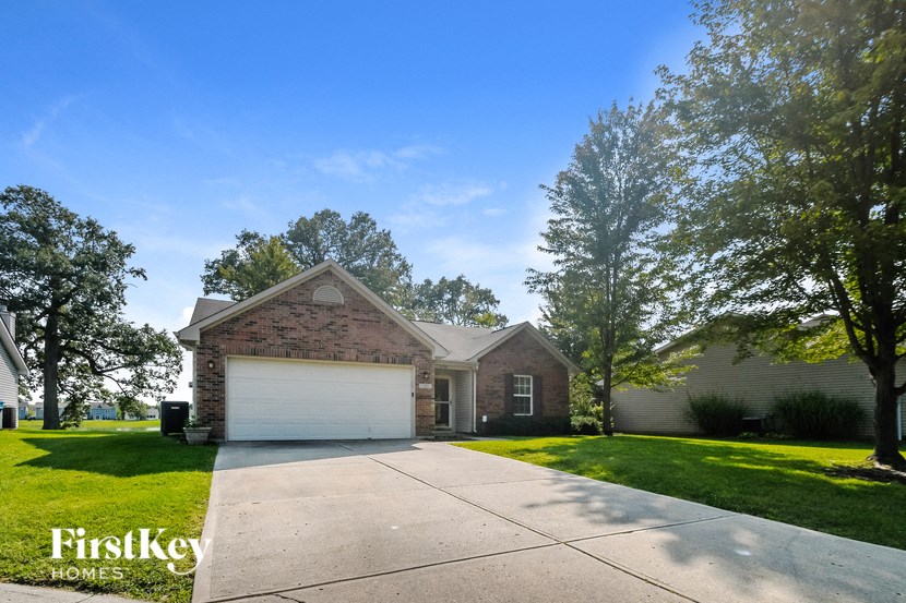 front view of a brick house with a white garage door